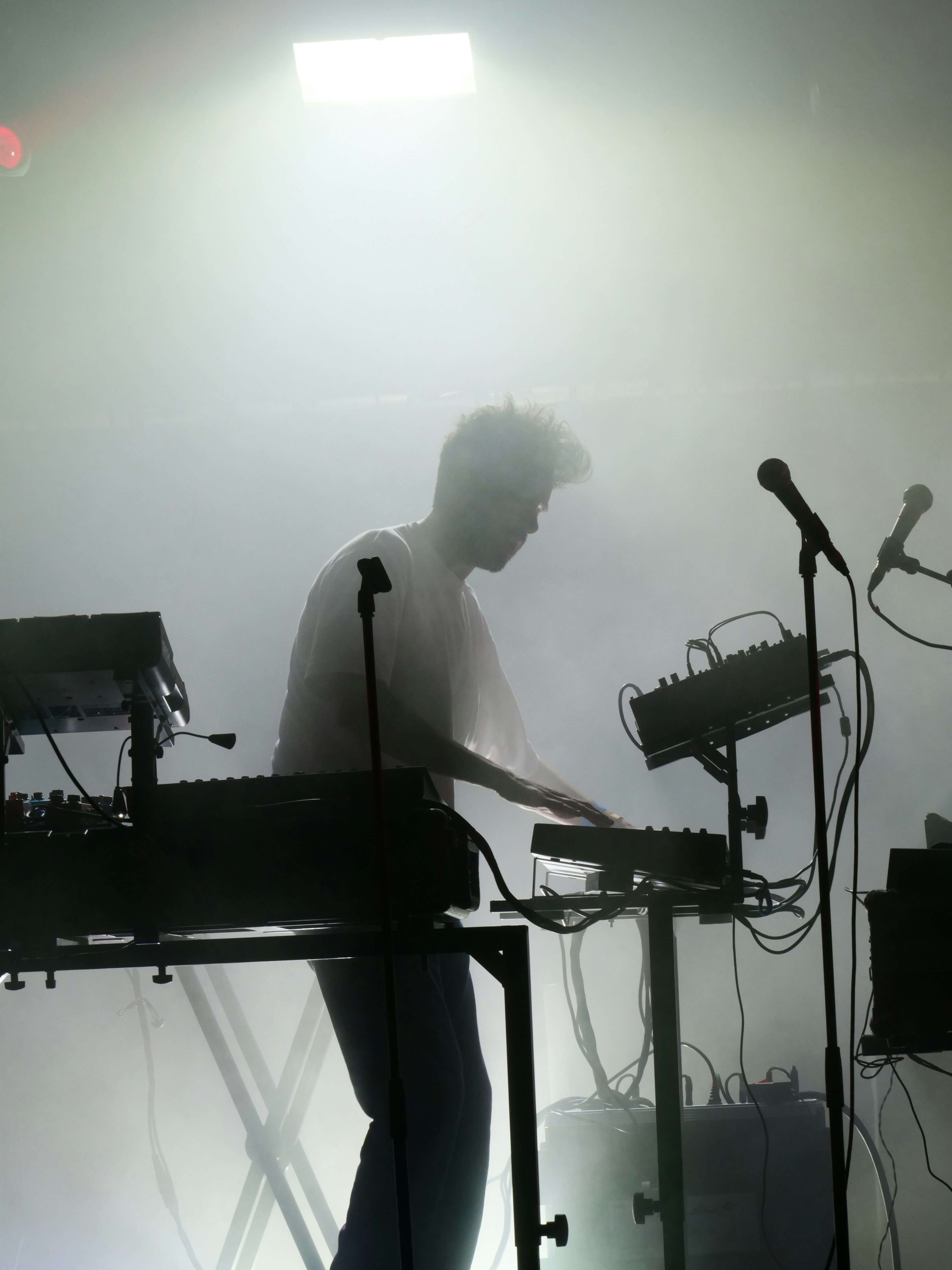 Musician playing synths in stage fog